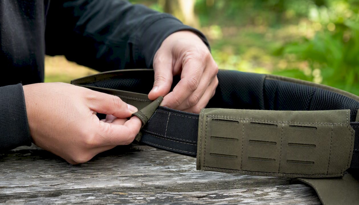Hands assembling two-piece tactical belt
